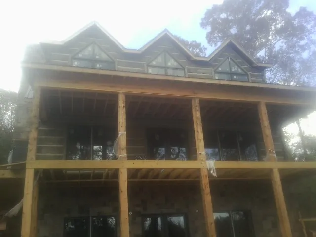 Dormers and porch framing on a large log home under construction — Roof Coating work by our crew in Long Creek