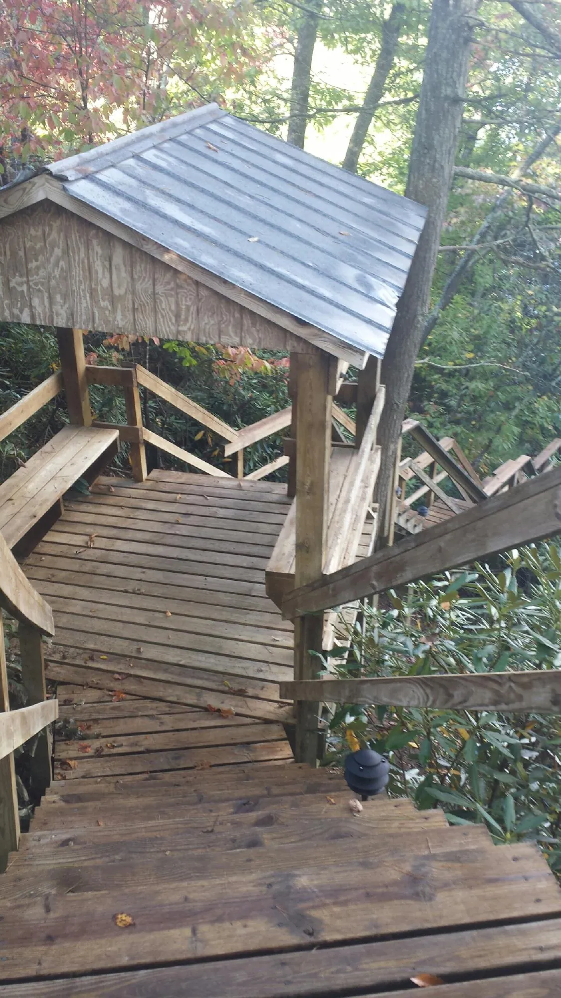 Metal roofed shelter over wooden steps on a wooded walkway — Skylight Repair & Installation work by our crew in Long Creek