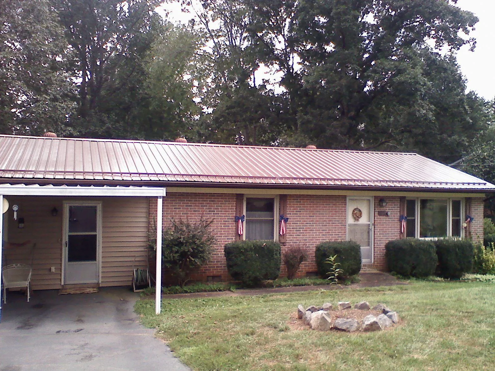 Bronze metal roof and carport on a brick ranch home — Roof Repair work by our crew in Long Creek